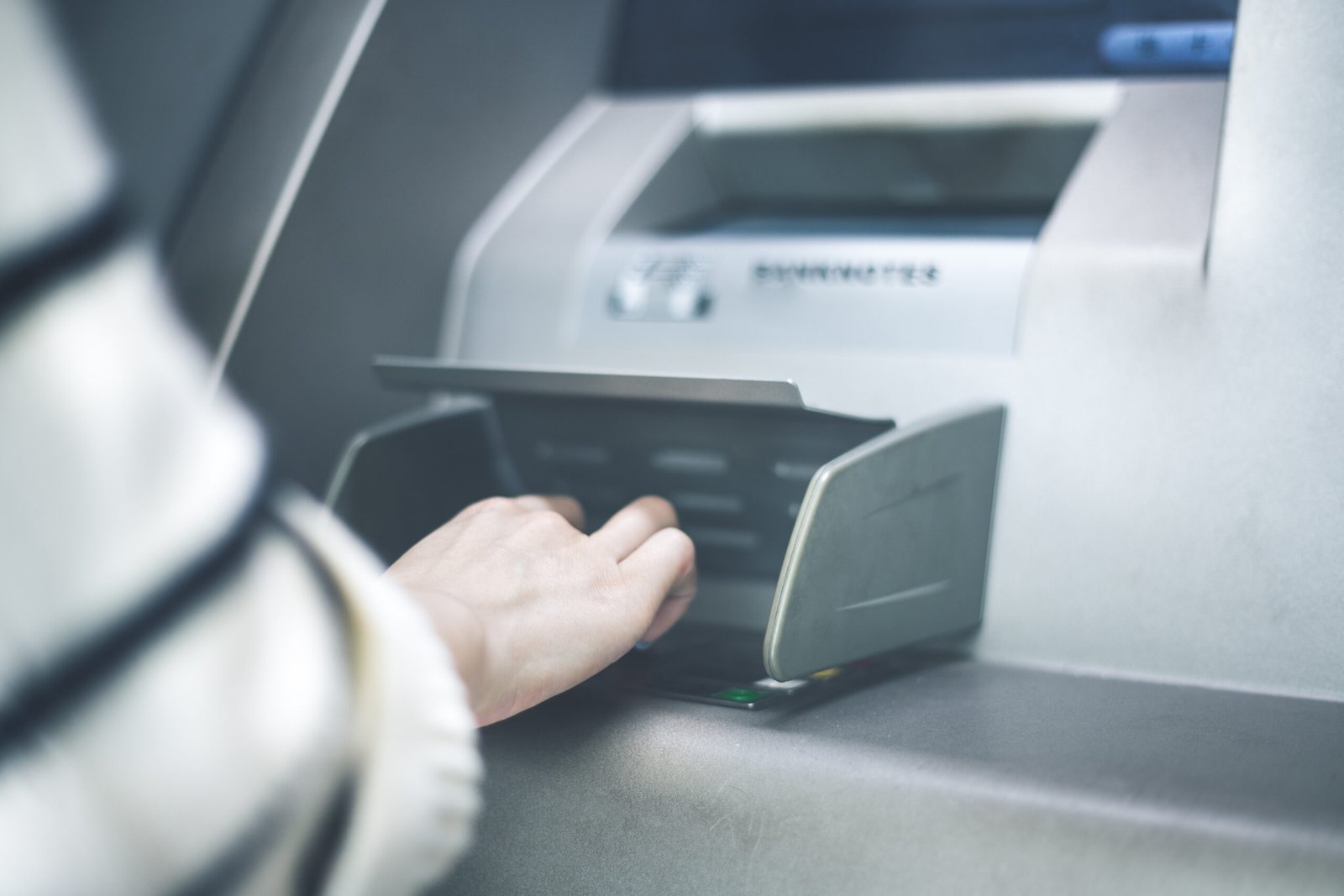 Woman using cash machine-ATM,close up view.